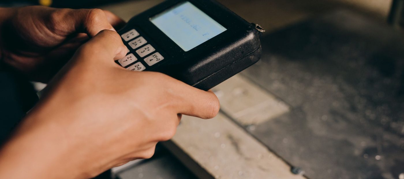 A detailed close-up of hands operating an electronic control device, capturing the precision of modern technology use.