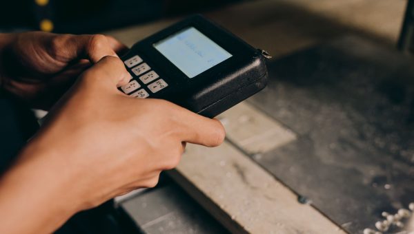 A detailed close-up of hands operating an electronic control device, capturing the precision of modern technology use.