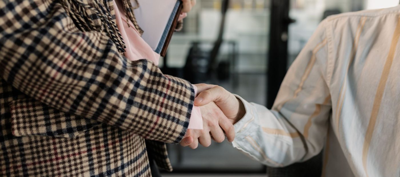 Close-up of a handshake between two professionals in a business environment.