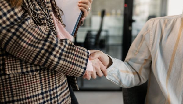 Close-up of a handshake between two professionals in a business environment.